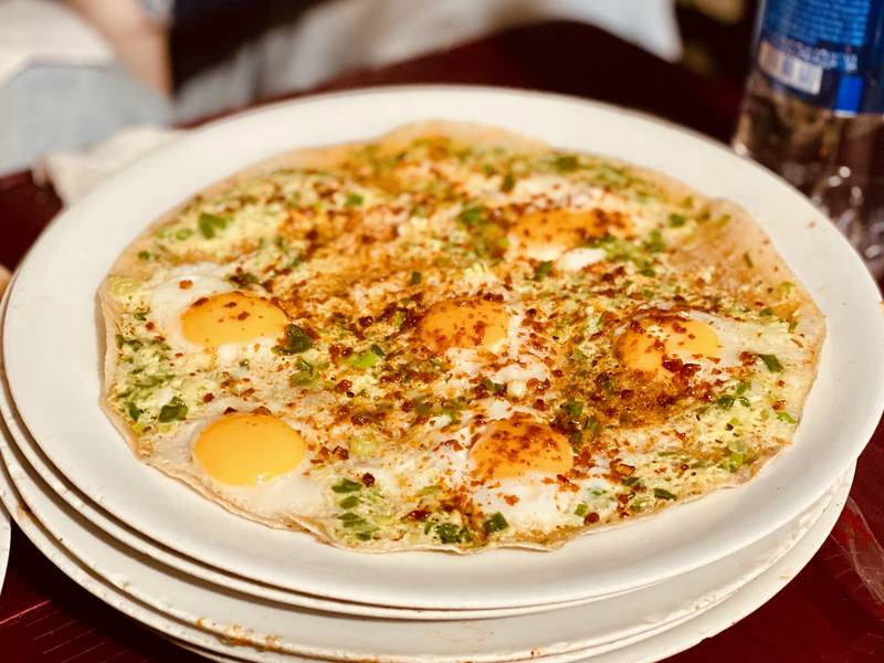 Bánh tráng nướng phủ trứng ốp la, hành lá và ớt