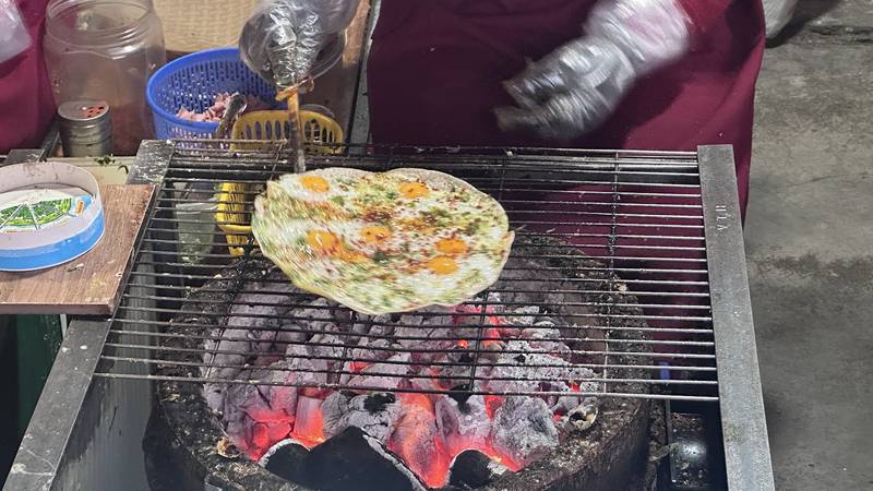 Bánh tráng nướng với trứng cút trên vỉ than hồng tại quầy Dì Đinh
