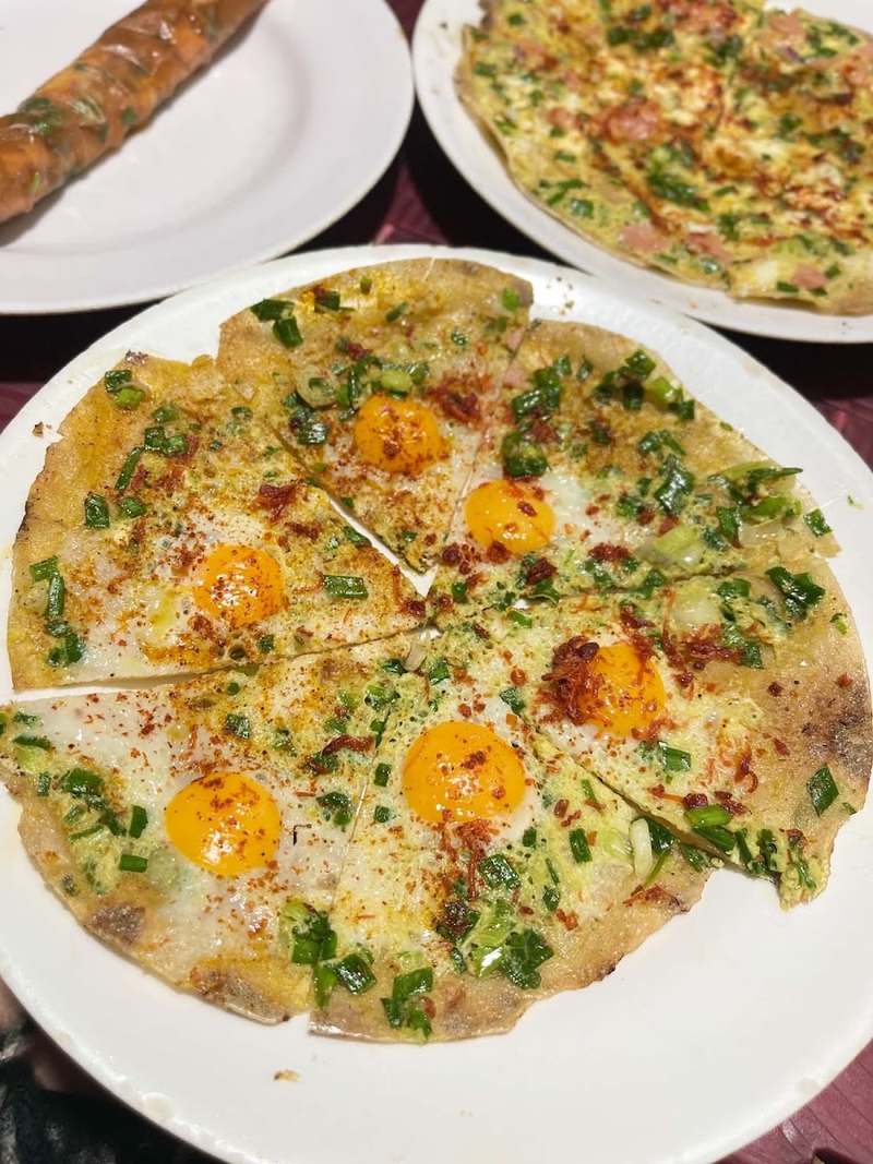 Bánh tráng nướng trứng cắt miếng, bên cạnh là bánh cuộn